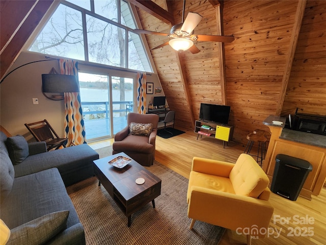 living room featuring a high ceiling, a ceiling fan, and wood finished floors