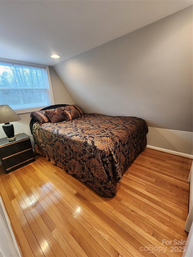 bedroom featuring light wood-type flooring and lofted ceiling