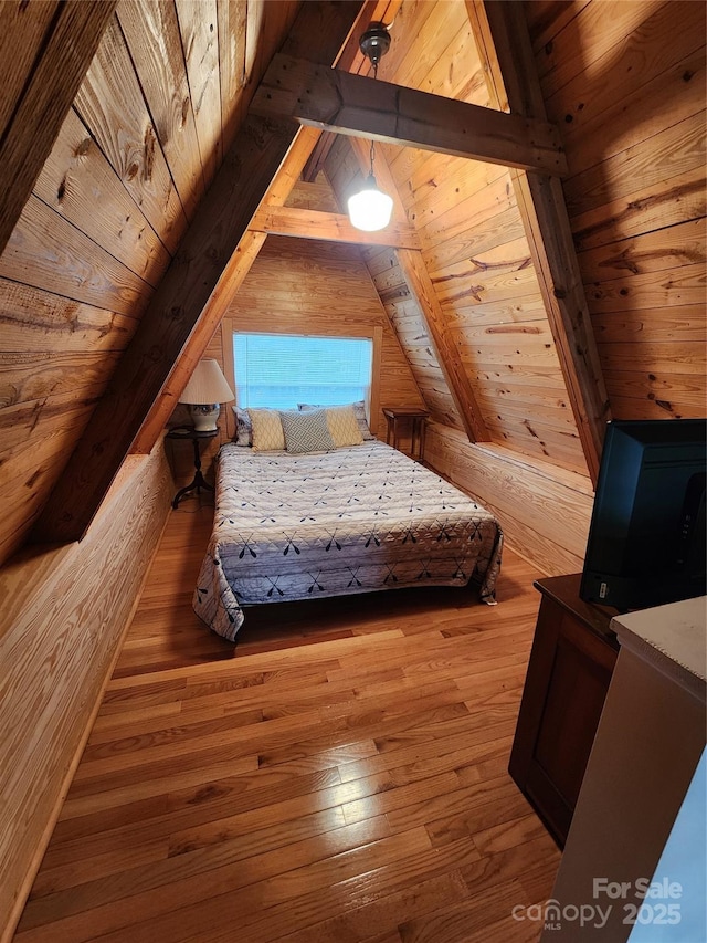 unfurnished bedroom featuring lofted ceiling with beams, wooden walls, hardwood / wood-style floors, and wooden ceiling