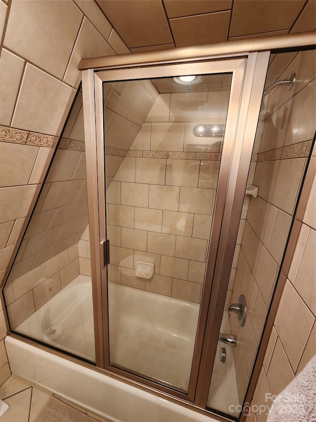 bathroom featuring bath / shower combo with glass door