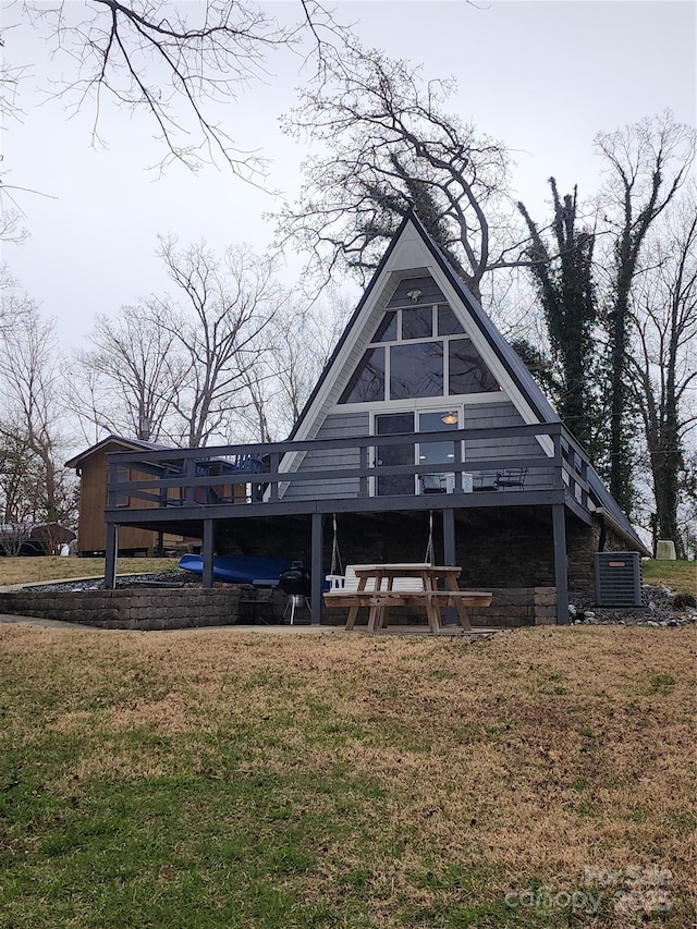 back of house featuring central air condition unit, a yard, and a wooden deck