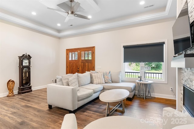 living area with visible vents, baseboards, wood finished floors, and a fireplace