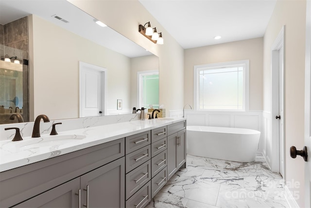 bathroom with visible vents, double vanity, wainscoting, marble finish floor, and a sink