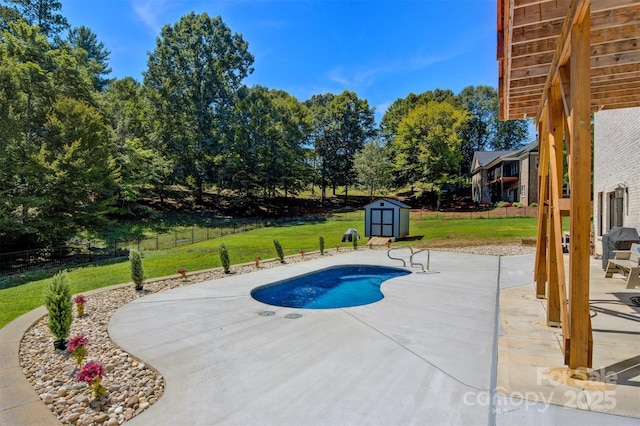 view of swimming pool with a storage unit, a patio, fence, a yard, and an outdoor structure