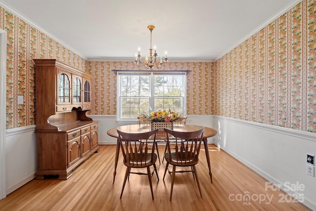 dining area with wallpapered walls, a wainscoted wall, and a chandelier