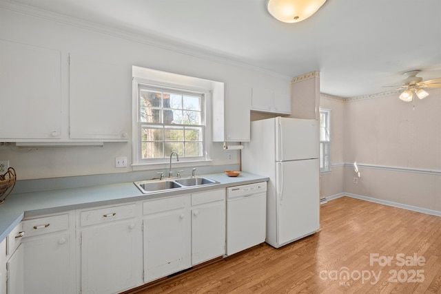 kitchen with light countertops, light wood-style floors, white appliances, white cabinetry, and a sink