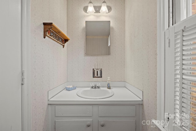 bathroom with wallpapered walls and vanity