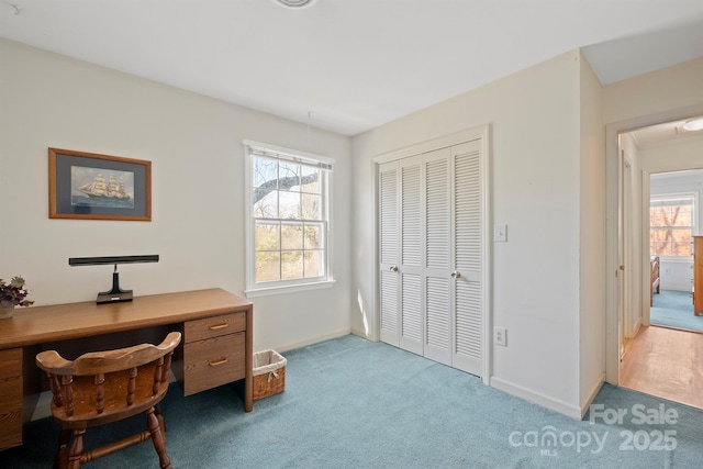 home office with baseboards, light colored carpet, and attic access