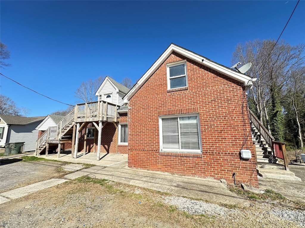 exterior space featuring brick siding and stairs