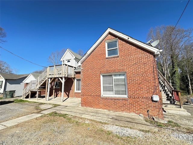 exterior space featuring brick siding and stairs