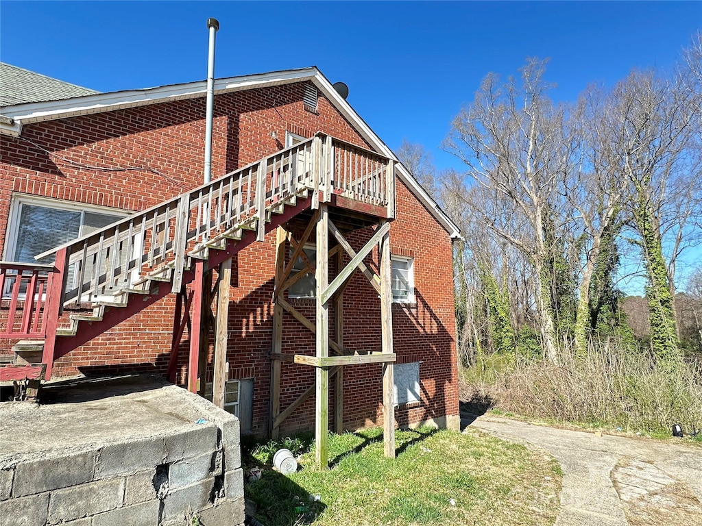 view of side of home with stairway and brick siding