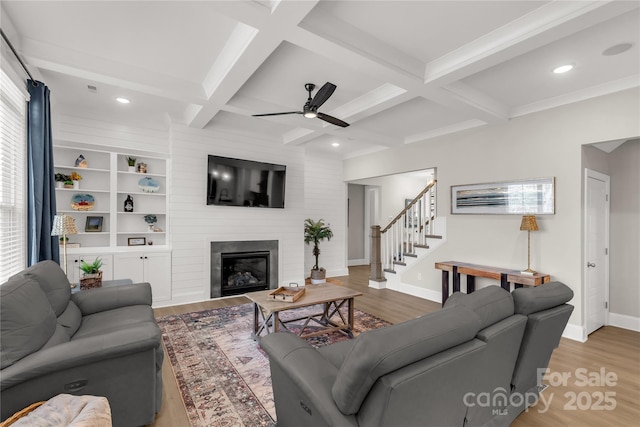 living room featuring stairway, beamed ceiling, and wood finished floors