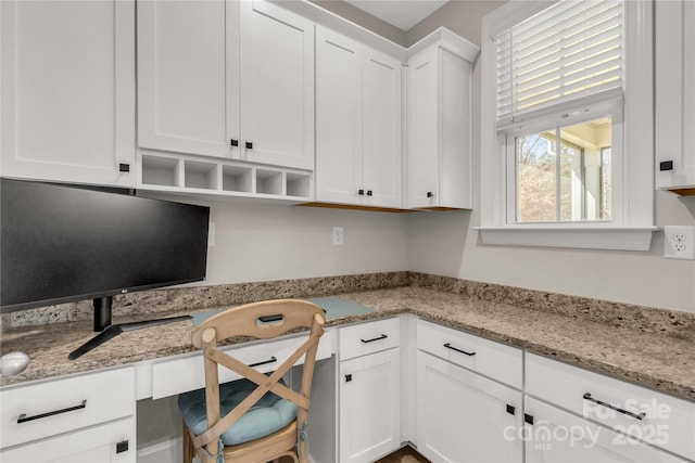 kitchen with open shelves, light stone countertops, and white cabinets