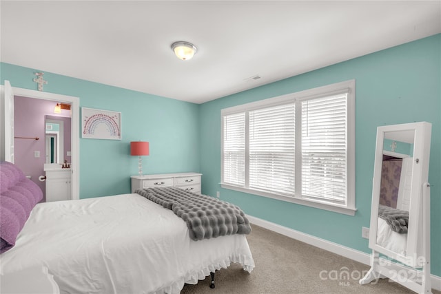 carpeted bedroom with visible vents, baseboards, and ensuite bath