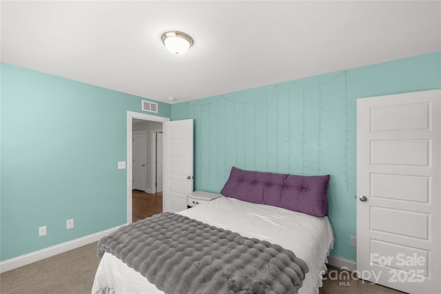 bedroom featuring visible vents, baseboards, and carpet