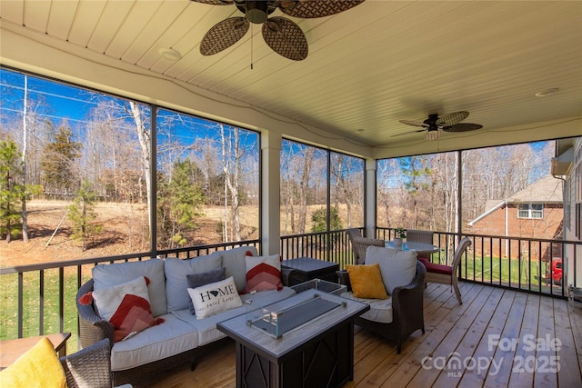 sunroom featuring wood ceiling and a ceiling fan