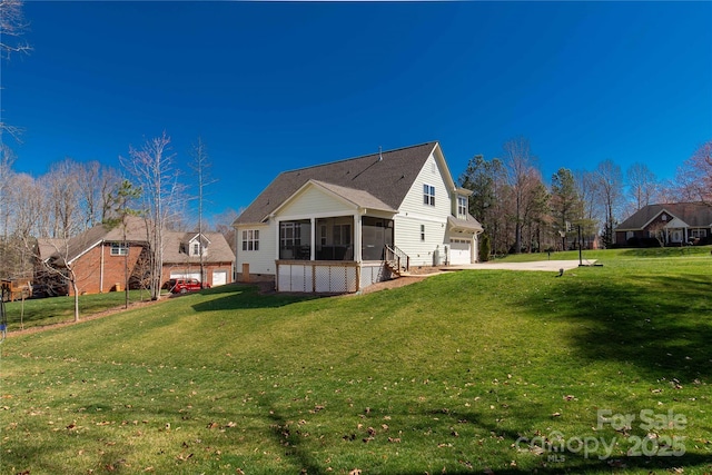 back of property featuring a garage, a lawn, driveway, and a sunroom