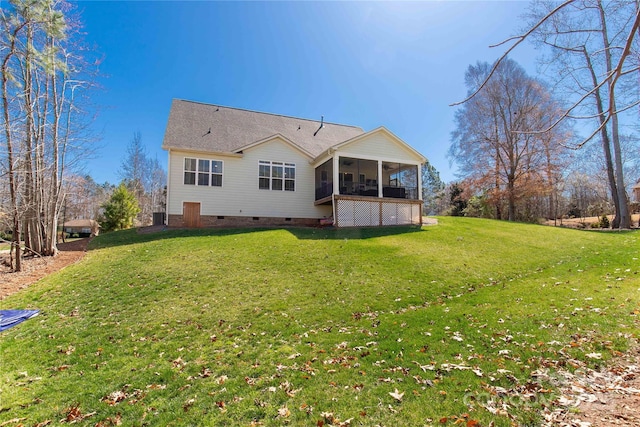 rear view of house with crawl space, a lawn, and a sunroom