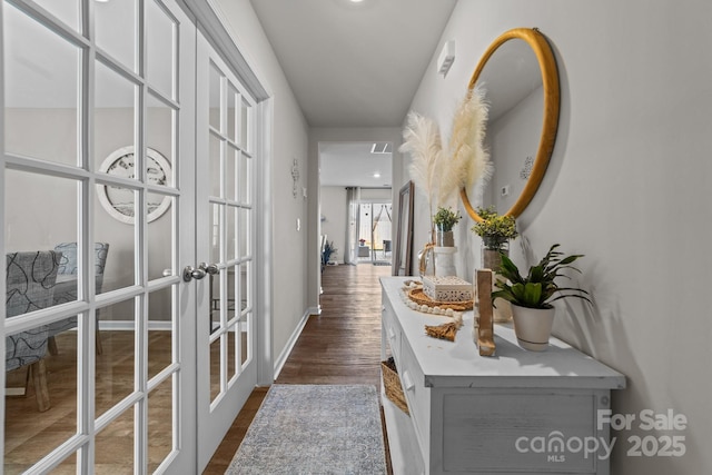 hallway featuring french doors, dark wood-type flooring, and baseboards