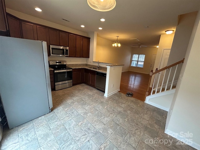kitchen with a sink, stainless steel appliances, a peninsula, and recessed lighting