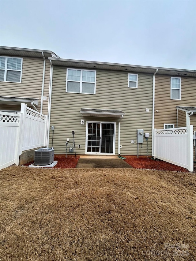 back of house with a yard, central AC, and fence