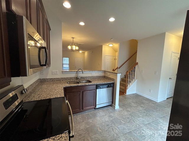 kitchen featuring a peninsula, a sink, stainless steel appliances, dark brown cabinets, and a chandelier