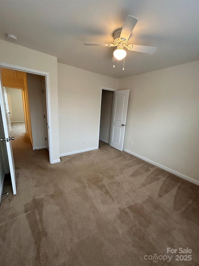 unfurnished bedroom with baseboards, carpet, and a ceiling fan