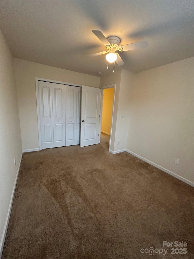 unfurnished bedroom with a closet, baseboards, carpet, and ceiling fan