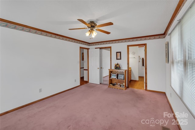 empty room featuring ceiling fan, baseboards, carpet, and ornamental molding