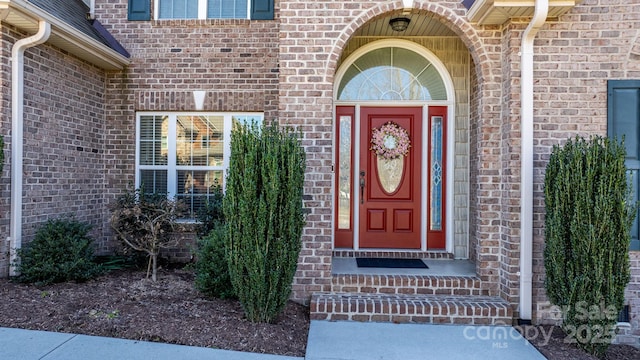 doorway to property featuring brick siding