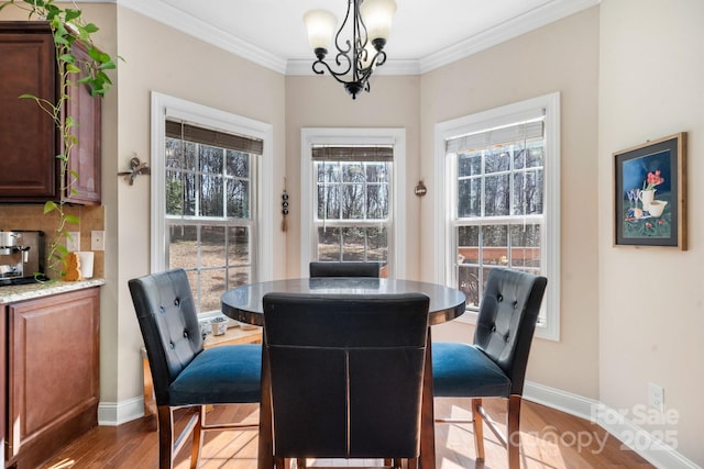 dining area with a notable chandelier, wood finished floors, baseboards, and ornamental molding