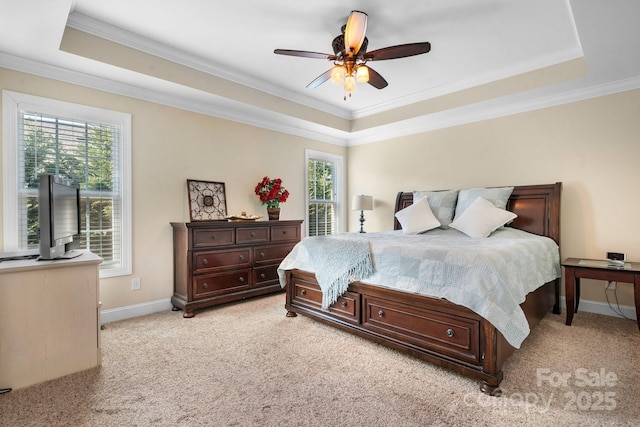 bedroom with multiple windows, light colored carpet, a raised ceiling, and baseboards