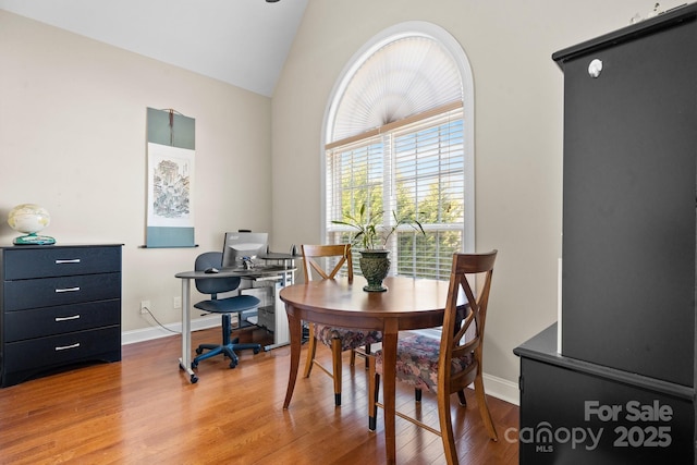 dining area with baseboards, lofted ceiling, and wood finished floors