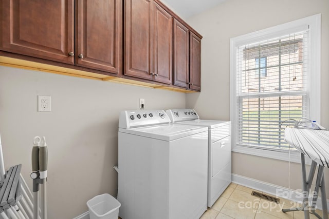 laundry room with light tile patterned floors, visible vents, baseboards, cabinet space, and washer and dryer