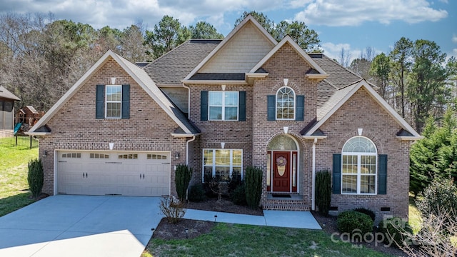 view of front of home with a front lawn, a garage, brick siding, and driveway