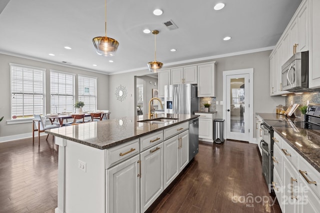 kitchen featuring visible vents, ornamental molding, a sink, backsplash, and stainless steel appliances