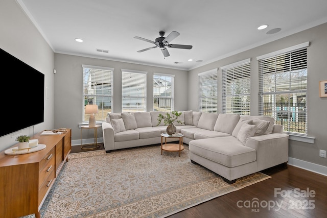 living area featuring dark wood-style flooring, baseboards, and ornamental molding