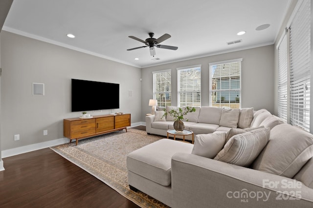 living area with dark wood-style floors, visible vents, baseboards, ceiling fan, and crown molding