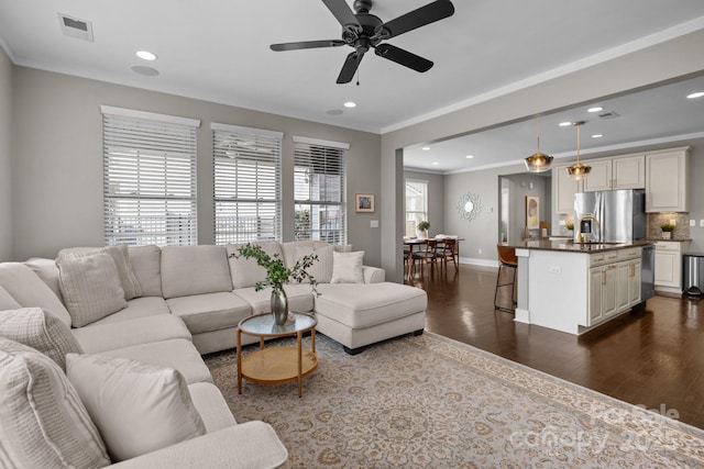 living room with visible vents, dark wood finished floors, recessed lighting, crown molding, and baseboards