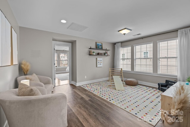 living area featuring visible vents, recessed lighting, baseboards, and wood finished floors