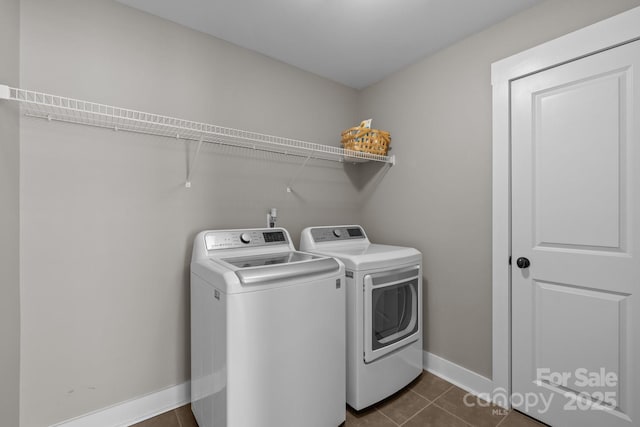 laundry room with baseboards, dark tile patterned flooring, independent washer and dryer, and laundry area