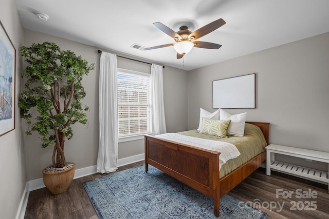 bedroom featuring visible vents, a ceiling fan, baseboards, and wood finished floors