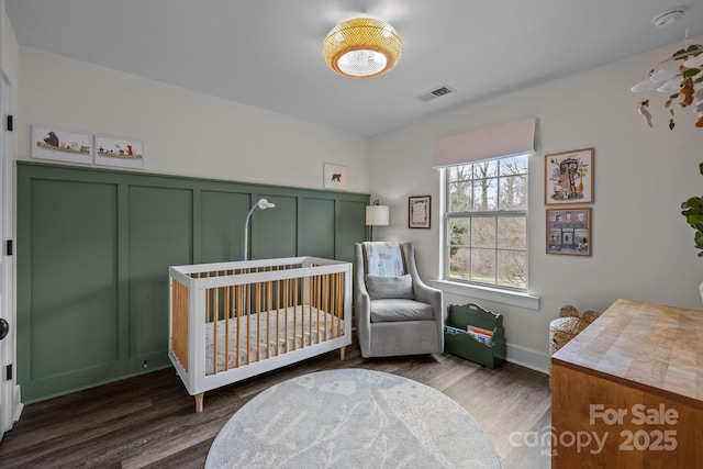 bedroom with dark wood finished floors and visible vents