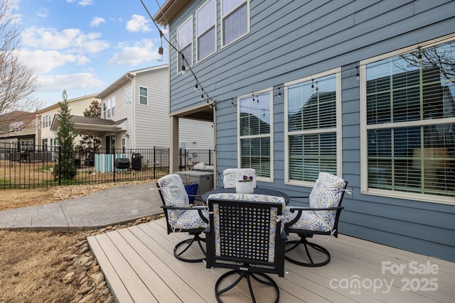 deck with outdoor dining area and fence