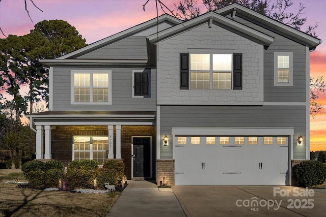 view of front of house with a garage, brick siding, and driveway