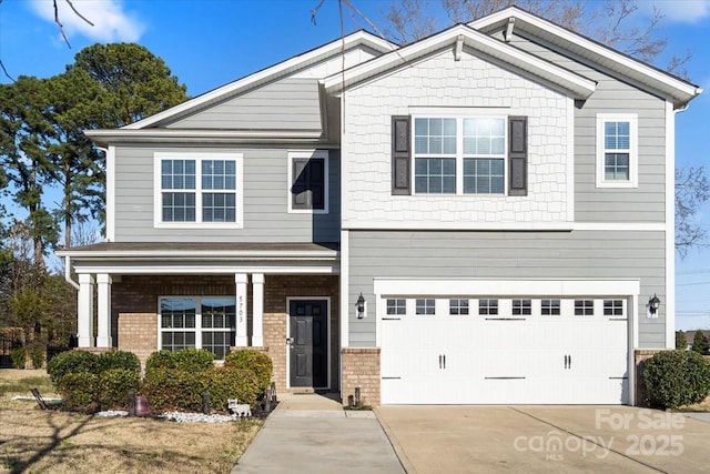 craftsman house with driveway, brick siding, and an attached garage