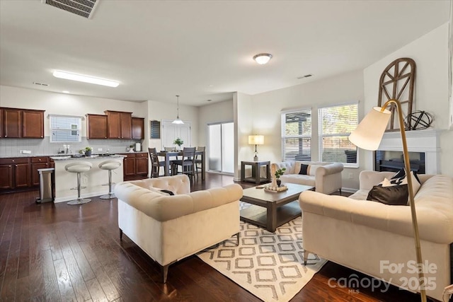 living room with visible vents and dark wood finished floors