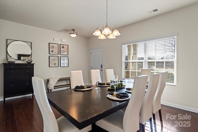 dining space featuring a chandelier, visible vents, dark wood-type flooring, and baseboards