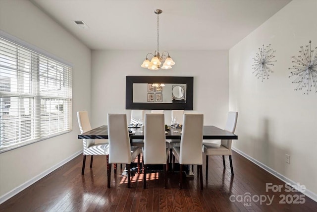 dining room with an inviting chandelier, baseboards, visible vents, and wood-type flooring