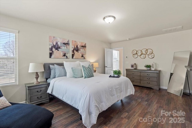 bedroom with baseboards and dark wood-style flooring